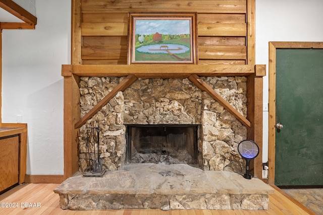 room details with hardwood / wood-style floors and a stone fireplace