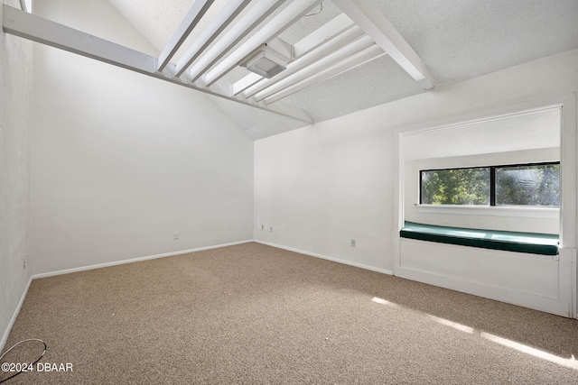 unfurnished room with carpet flooring, a textured ceiling, and vaulted ceiling