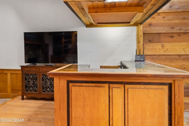 bar featuring light wood-type flooring, wooden walls, and wood ceiling