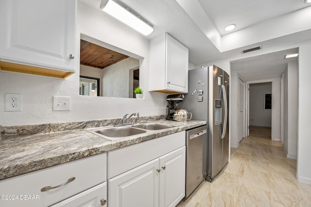 kitchen featuring white cabinetry, light stone counters, sink, and dishwasher