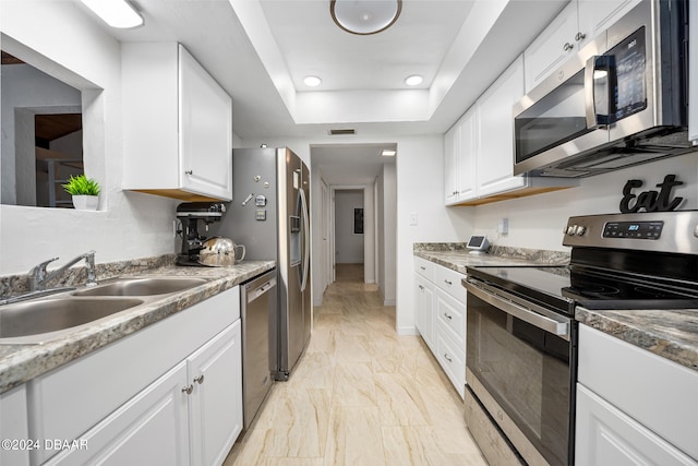 kitchen with white cabinetry, light stone counters, and stainless steel appliances