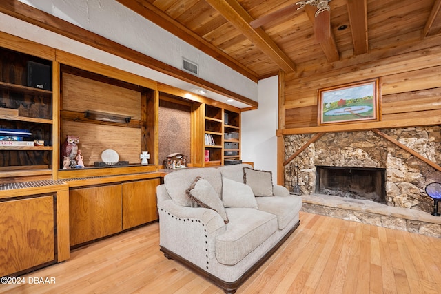 living room with beamed ceiling, a fireplace, wood ceiling, built in features, and light wood-type flooring