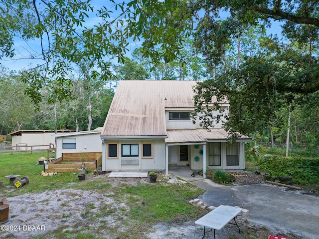 view of front of house with a front yard and a patio area