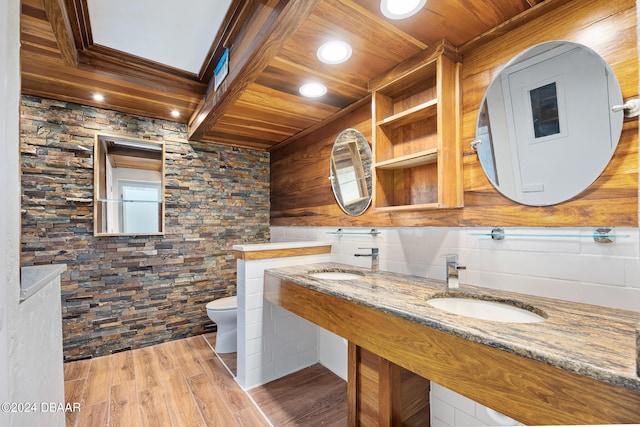 bathroom with hardwood / wood-style floors, wooden ceiling, dual sinks, and toilet