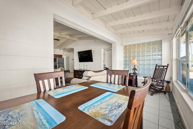 dining area featuring tile patterned floors, vaulted ceiling with beams, and wood ceiling