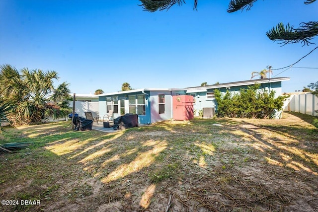 rear view of property with a lawn and a patio