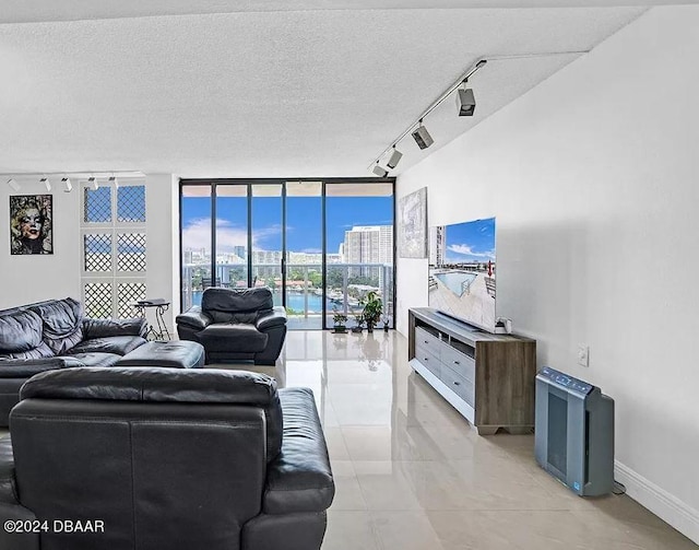 living room featuring a textured ceiling, floor to ceiling windows, and track lighting