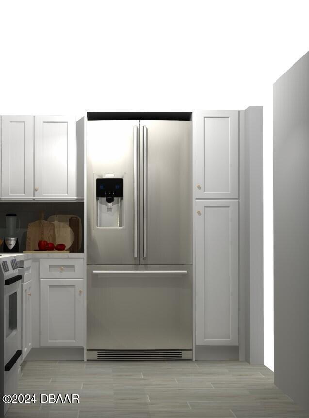 kitchen featuring white cabinets, stainless steel refrigerator with ice dispenser, and range