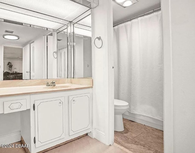 bathroom featuring tile patterned floors, vanity, toilet, and walk in shower