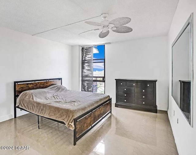 bedroom featuring ceiling fan and a textured ceiling