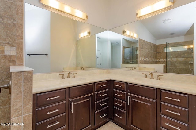 bathroom featuring vanity, tiled shower, and vaulted ceiling