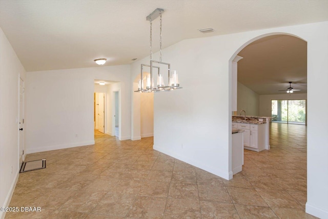 unfurnished dining area featuring ceiling fan with notable chandelier