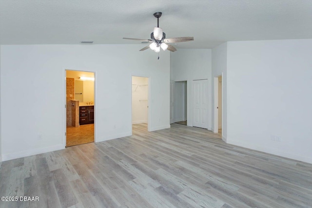 unfurnished bedroom with ceiling fan, light hardwood / wood-style floors, high vaulted ceiling, and ensuite bath