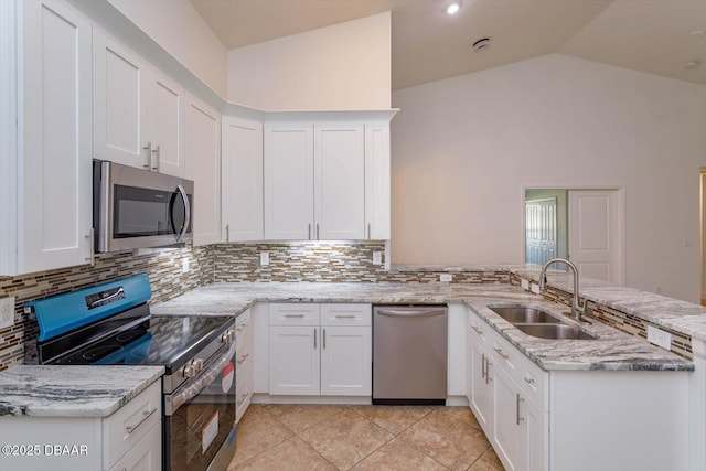 kitchen with kitchen peninsula, appliances with stainless steel finishes, and white cabinets