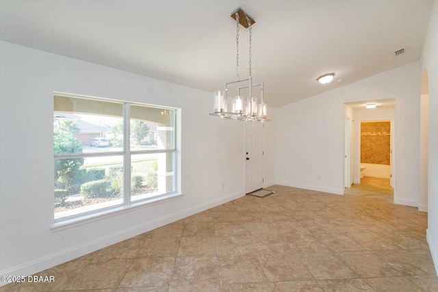 spare room with vaulted ceiling and a notable chandelier