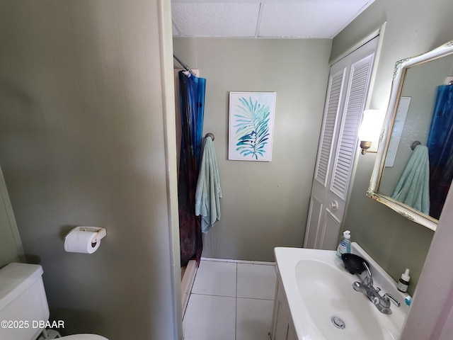 bathroom with toilet, a shower with shower curtain, a closet, tile patterned flooring, and vanity