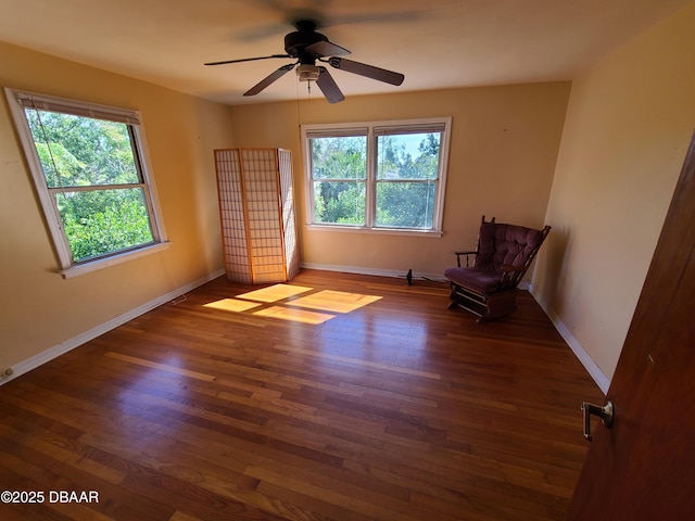 unfurnished room featuring baseboards, a healthy amount of sunlight, and wood finished floors