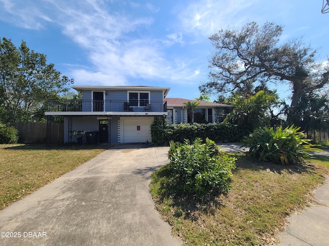 view of front facade with a front yard, a balcony, fence, driveway, and an attached garage