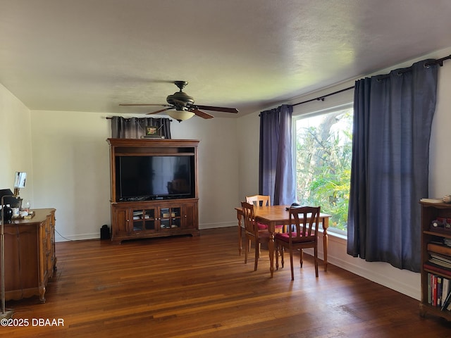 dining room featuring dark wood finished floors, baseboards, and ceiling fan