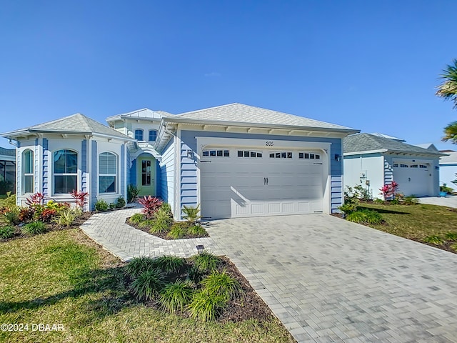 view of front of property featuring a garage and a front lawn