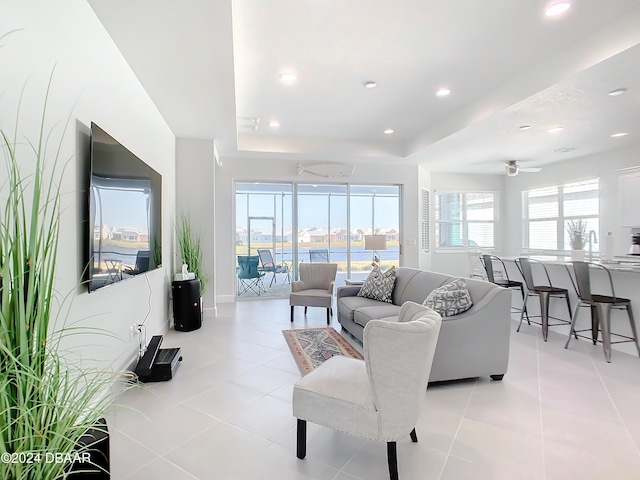 living room with ceiling fan, light tile patterned floors, and a wealth of natural light