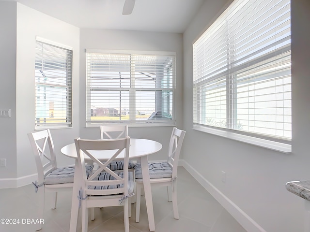 tiled dining room featuring breakfast area and ceiling fan