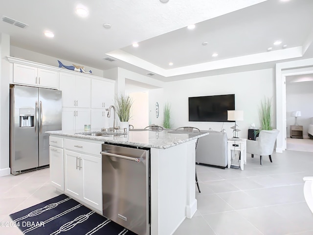 kitchen featuring white cabinets, a center island with sink, sink, and appliances with stainless steel finishes