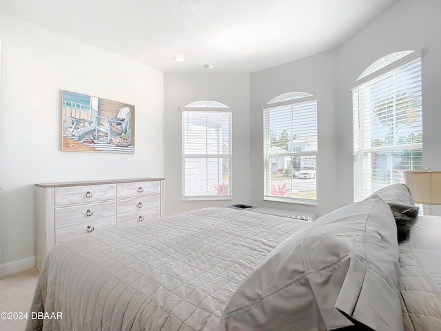 carpeted bedroom featuring multiple windows