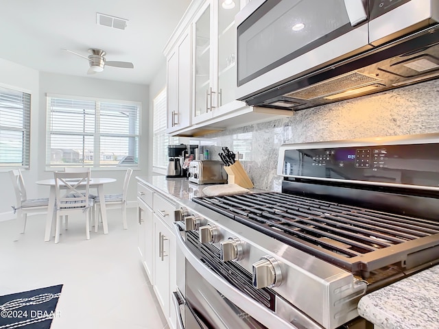 kitchen featuring white cabinets, ceiling fan, light stone countertops, and stainless steel appliances