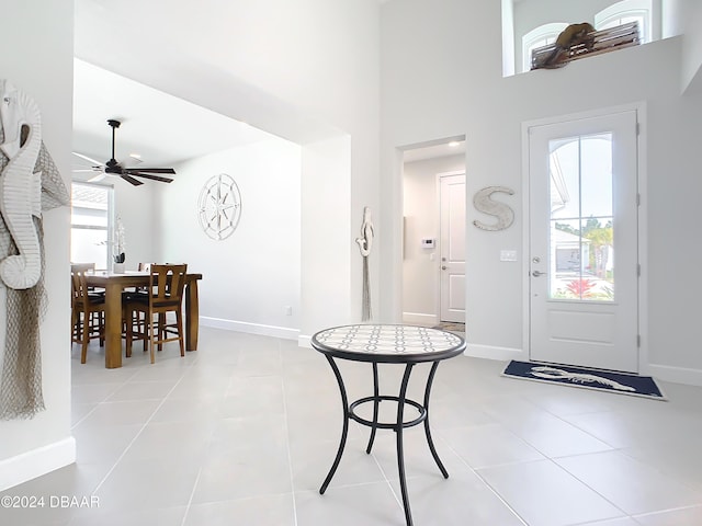 foyer entrance featuring a high ceiling, light tile patterned floors, and ceiling fan