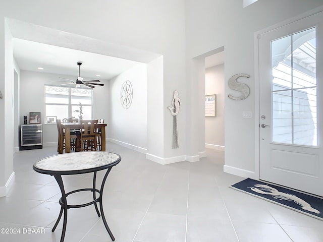 foyer featuring wine cooler, ceiling fan, and light tile patterned flooring