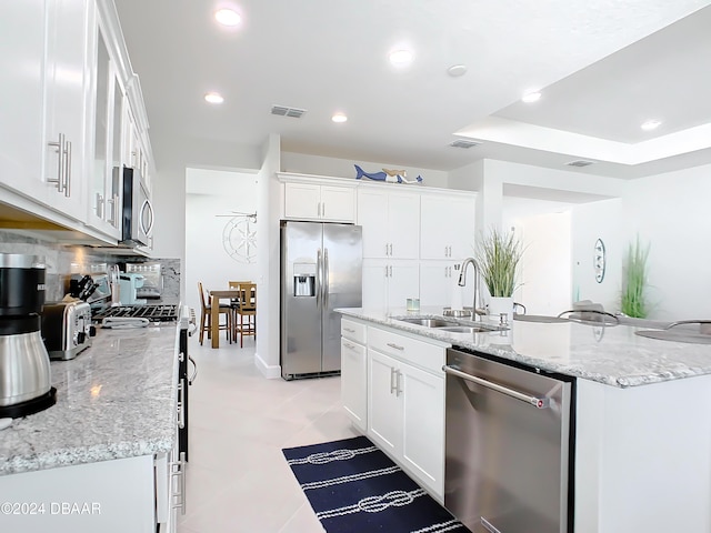 kitchen featuring appliances with stainless steel finishes, backsplash, white cabinetry, and sink