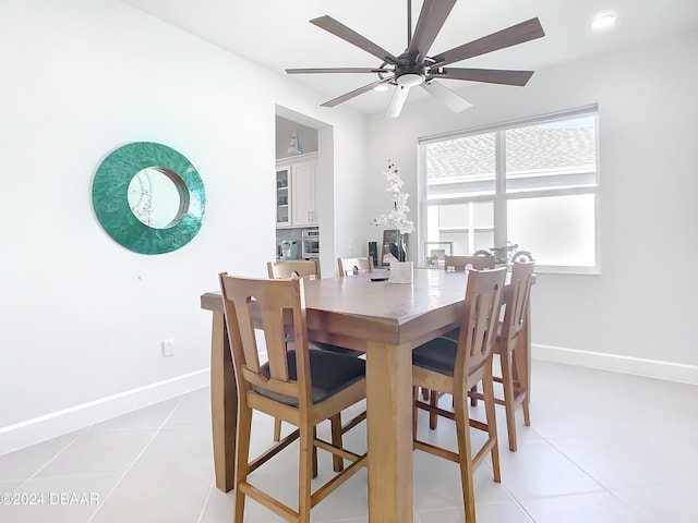 tiled dining space with ceiling fan