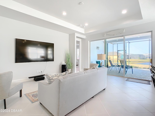 living room featuring light tile patterned floors and a tray ceiling