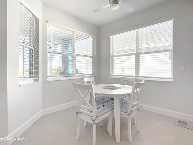 tiled dining space featuring plenty of natural light and ceiling fan