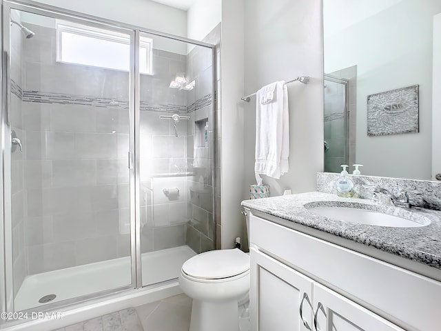 bathroom featuring tile patterned floors, toilet, an enclosed shower, and vanity