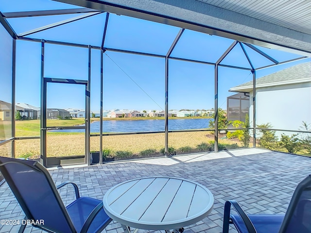 sunroom featuring a water view