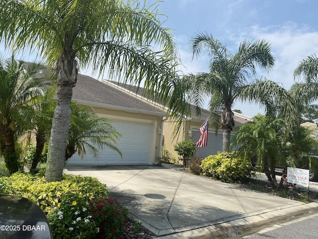 2273 Hawks Cove Cir, New Smyrna Beach, FL 32168 - view of front of house featuring driveway, a garage, roof with shingles, and stucco siding