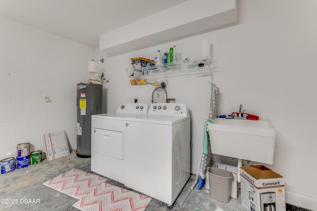 washroom with washing machine and clothes dryer, water heater, laundry area, concrete block wall, and a sink