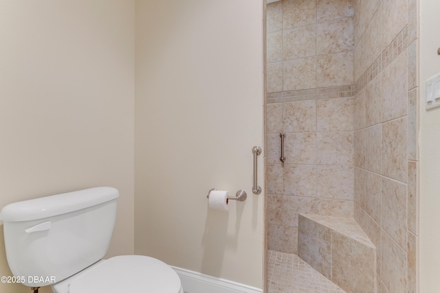 full bath featuring tiled shower and toilet