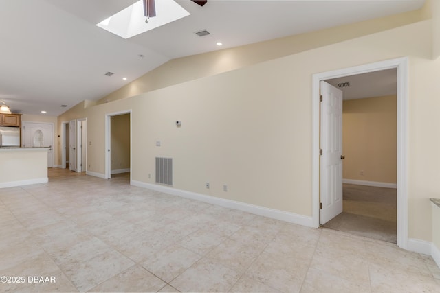 unfurnished living room featuring visible vents, lofted ceiling with skylight, baseboards, and a ceiling fan