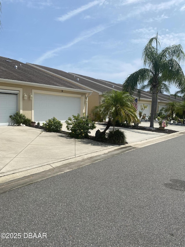 2273 Hawks Cove Cir, New Smyrna Beach, FL 32168 - view of side of property featuring driveway, stucco siding, and a garage