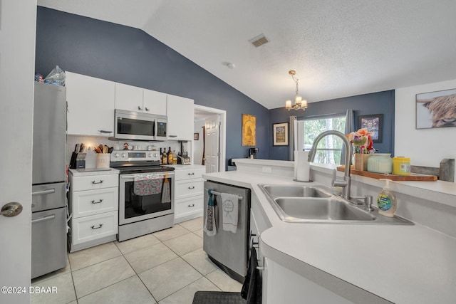 kitchen with pendant lighting, stainless steel appliances, lofted ceiling, and sink