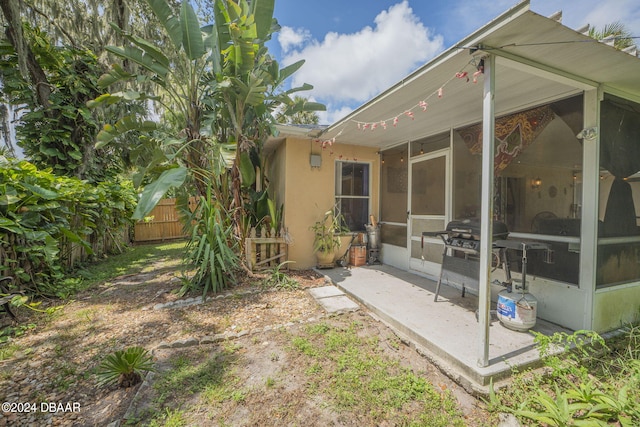 view of yard featuring a sunroom and a patio