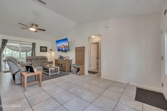 living room with a textured ceiling, ceiling fan, light tile patterned flooring, and lofted ceiling