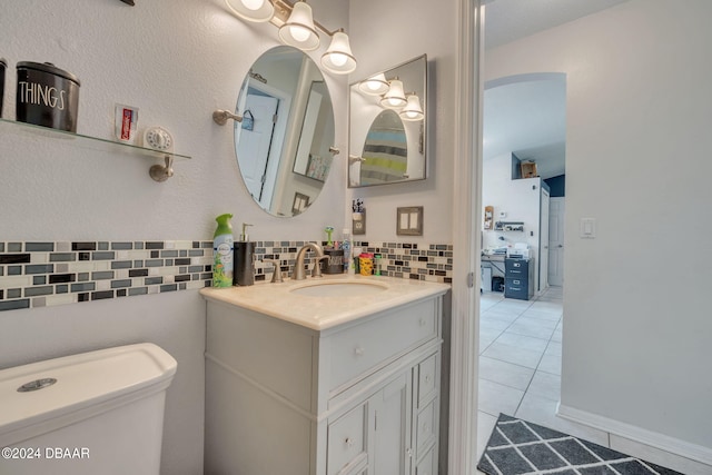 bathroom featuring tile patterned flooring, vanity, toilet, and backsplash