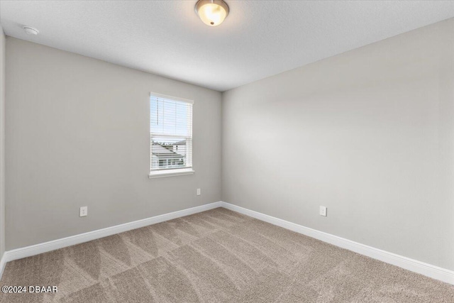 empty room featuring a textured ceiling and carpet floors