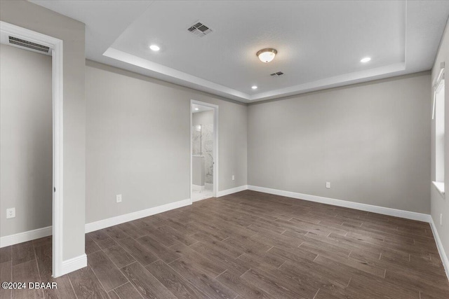 unfurnished room with dark hardwood / wood-style floors and a raised ceiling