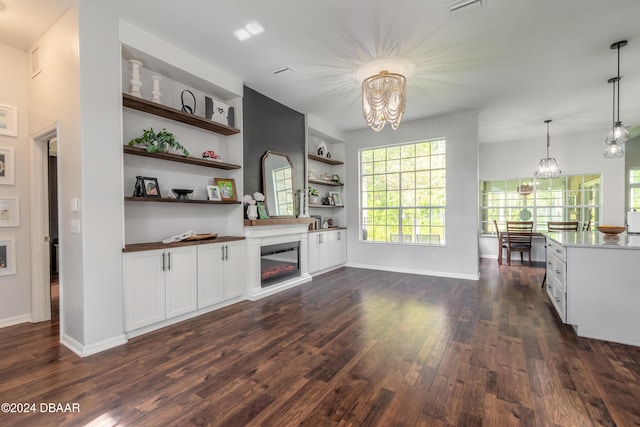 bar featuring built in features, white cabinetry, hanging light fixtures, an inviting chandelier, and dark wood-type flooring