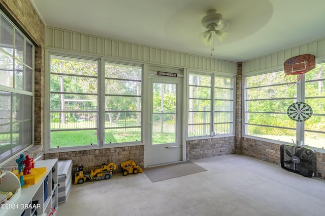 unfurnished sunroom featuring a wealth of natural light and ceiling fan